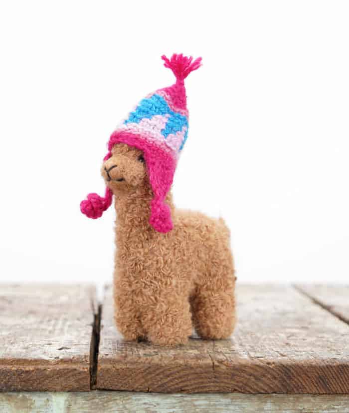 brown alpaca soft toy with purple hat