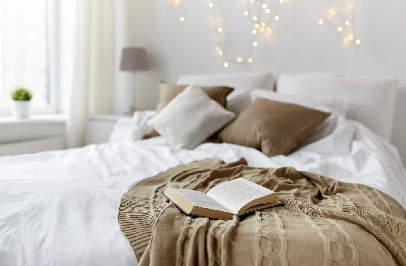 coziness comfort interior and holidays concept - cosy bedroom with