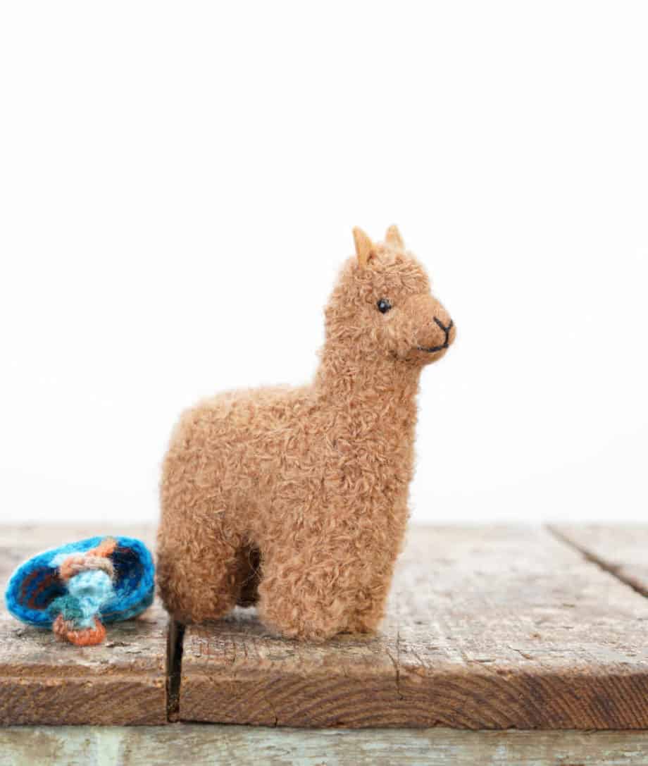 brown alpaca soft toy with turquoise hat
