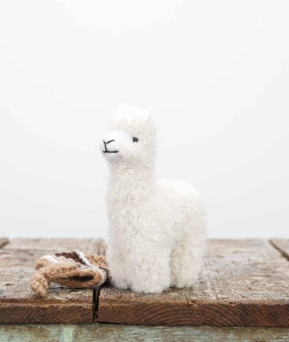 cute hand felted baby alpaca soft toy with a brown hat