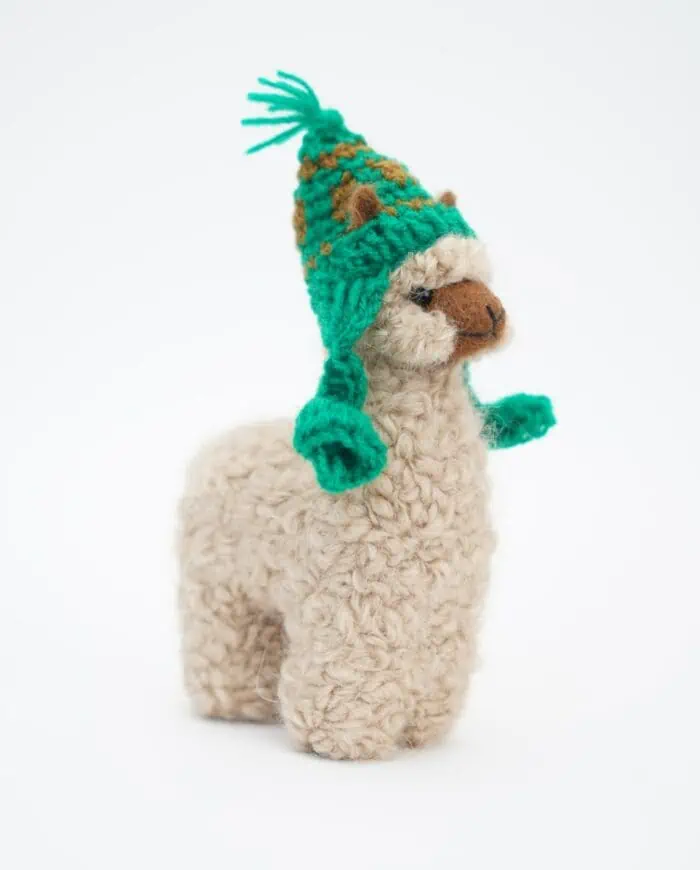 cute hand made beige baby alpaca soft toy with a green hat