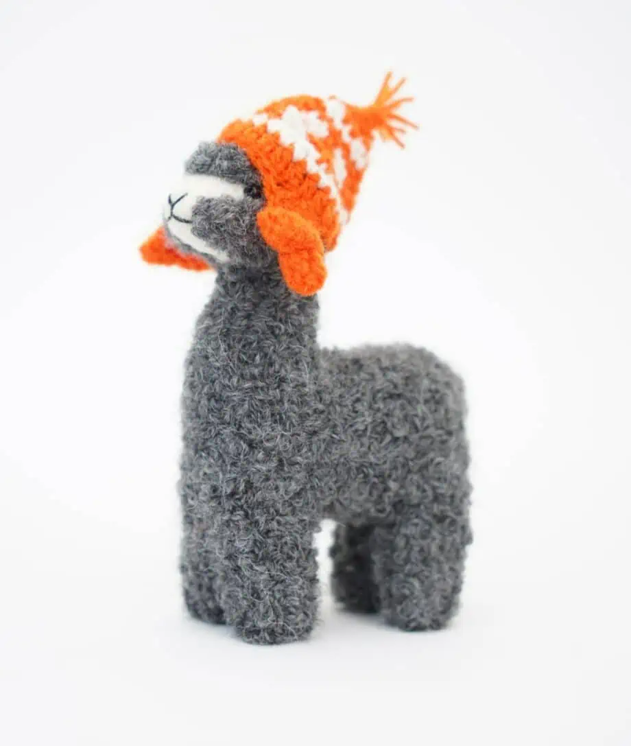 cute grey baby alpaca wool soft toy with an orange hat