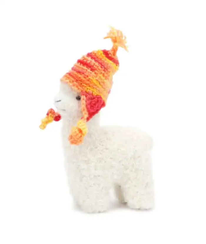super cute baby alpaca with a hand crochet orange hat