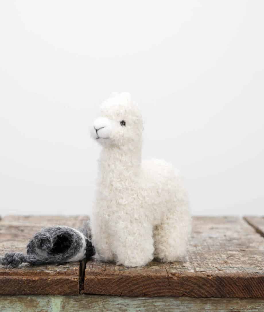 cute felted wool baby alpaca with a grey hat