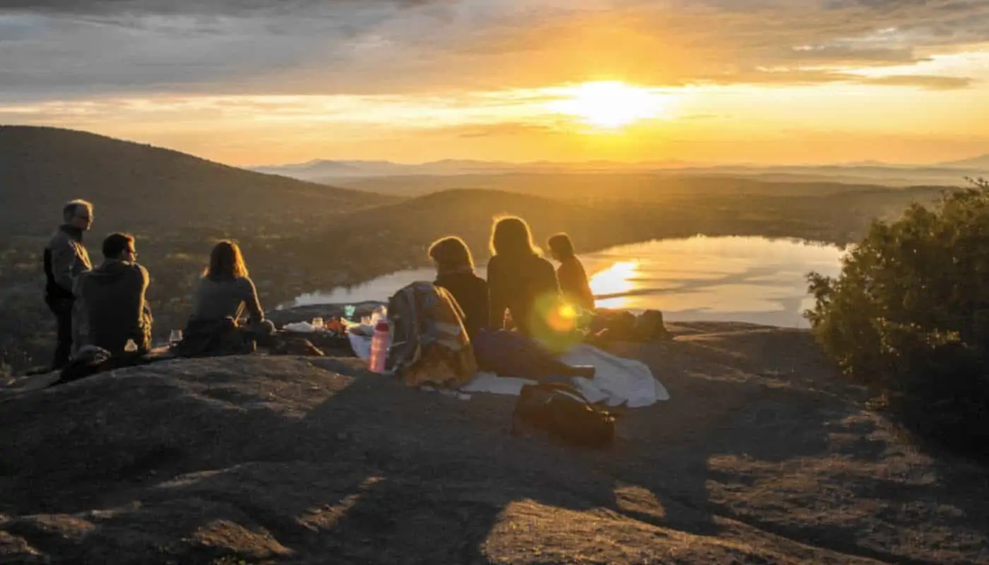 a group of people enjoying a sunset with a view