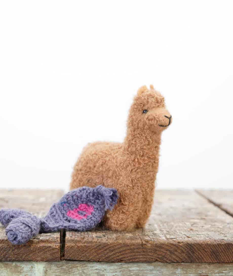 brown alpaca soft toy with violet blue hat