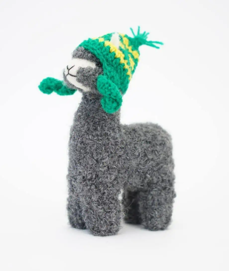 grey baby alpaca cosy soft toy with a green chullio hat
