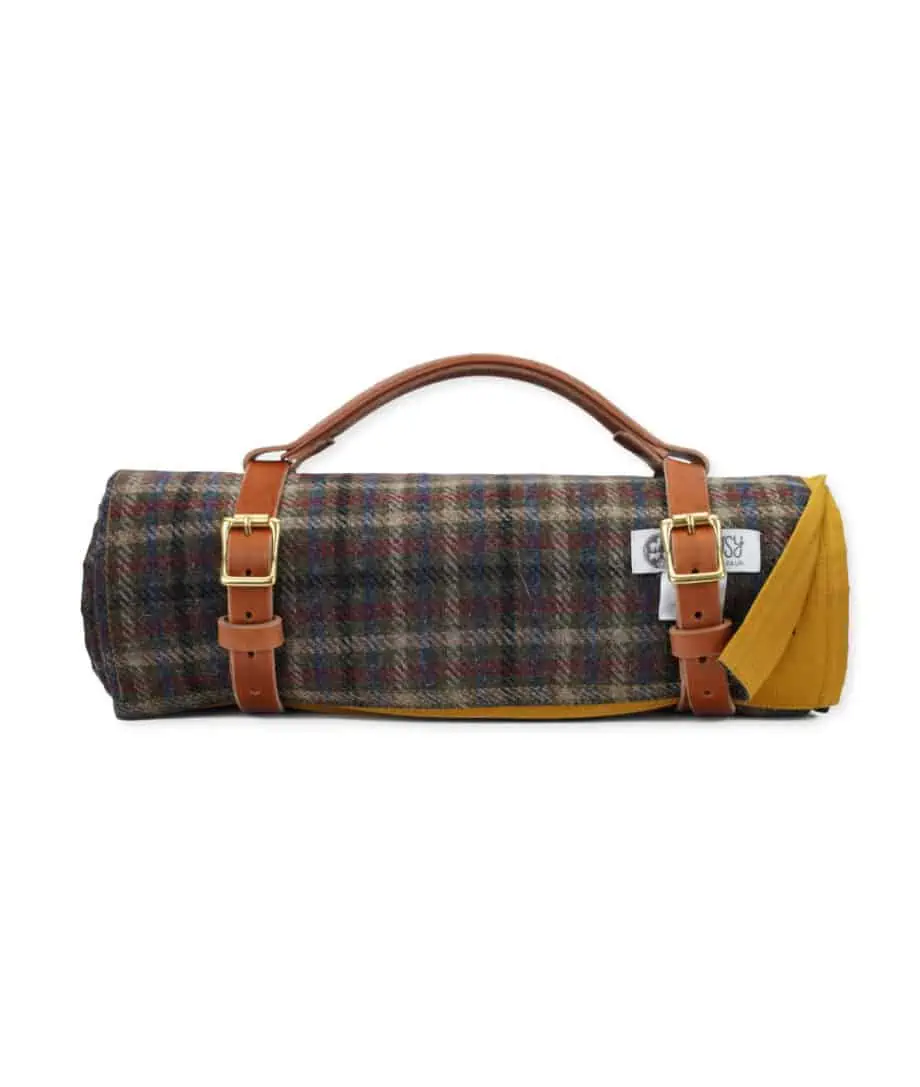 roll up mustard wax cotton and tartan wool picnic blanket with handmade leather straps