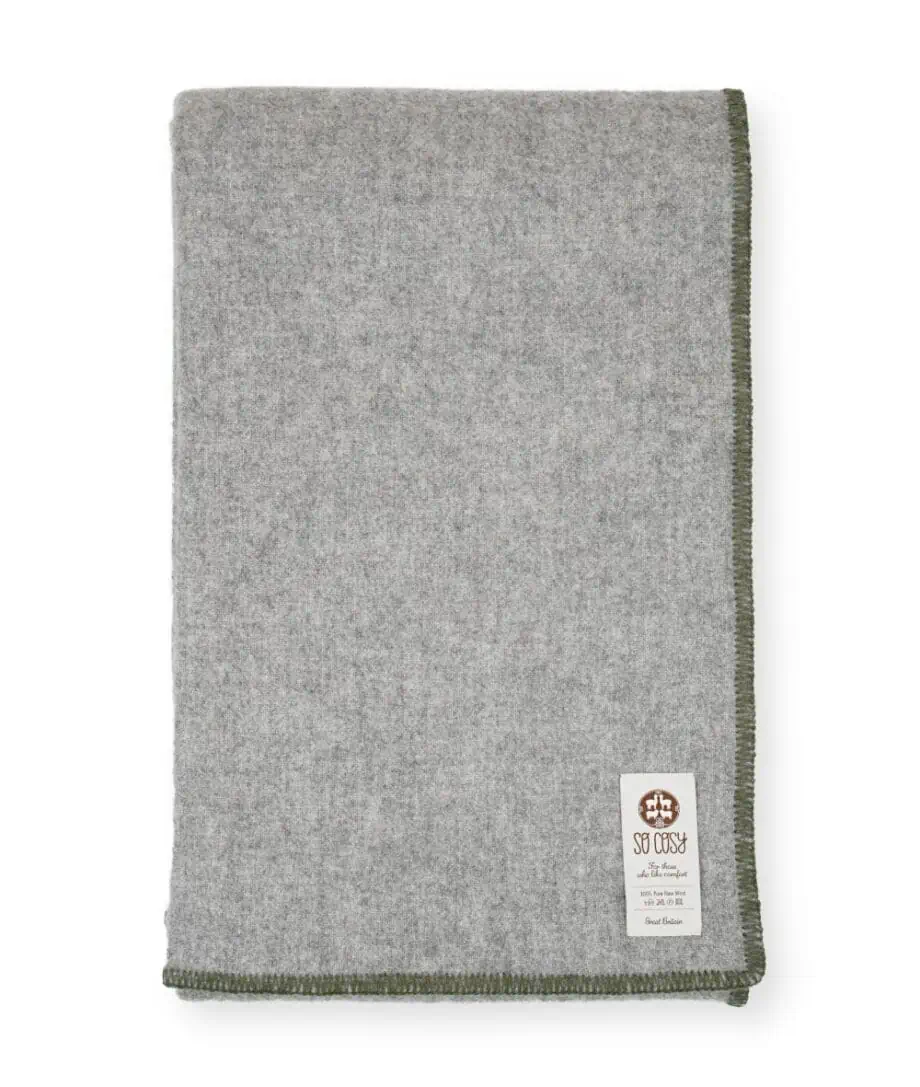 Della pure wool cosy blanket with forest green blanket stitch edge