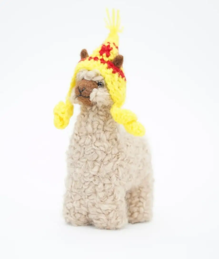adorable baby alpaca with a yellow hat