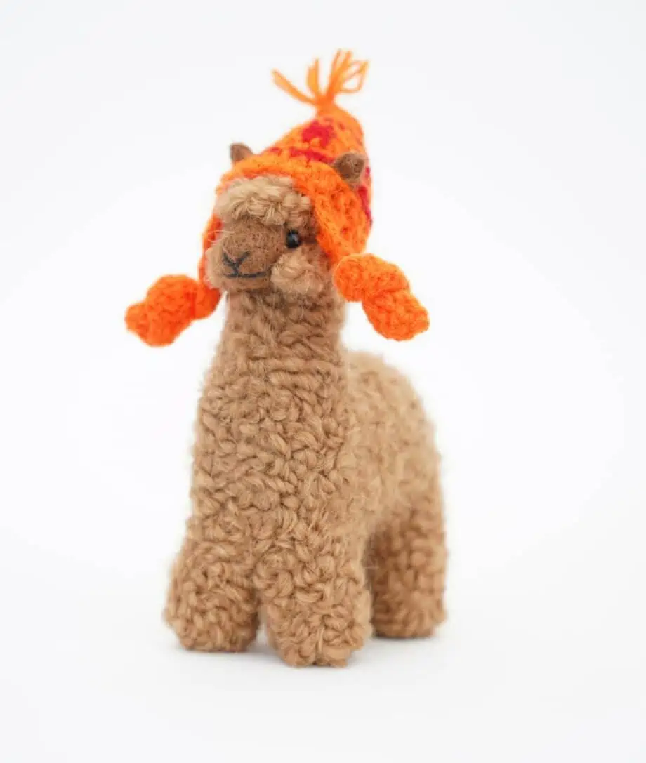 Cute brown baby alpaca soft toy with an orange hat