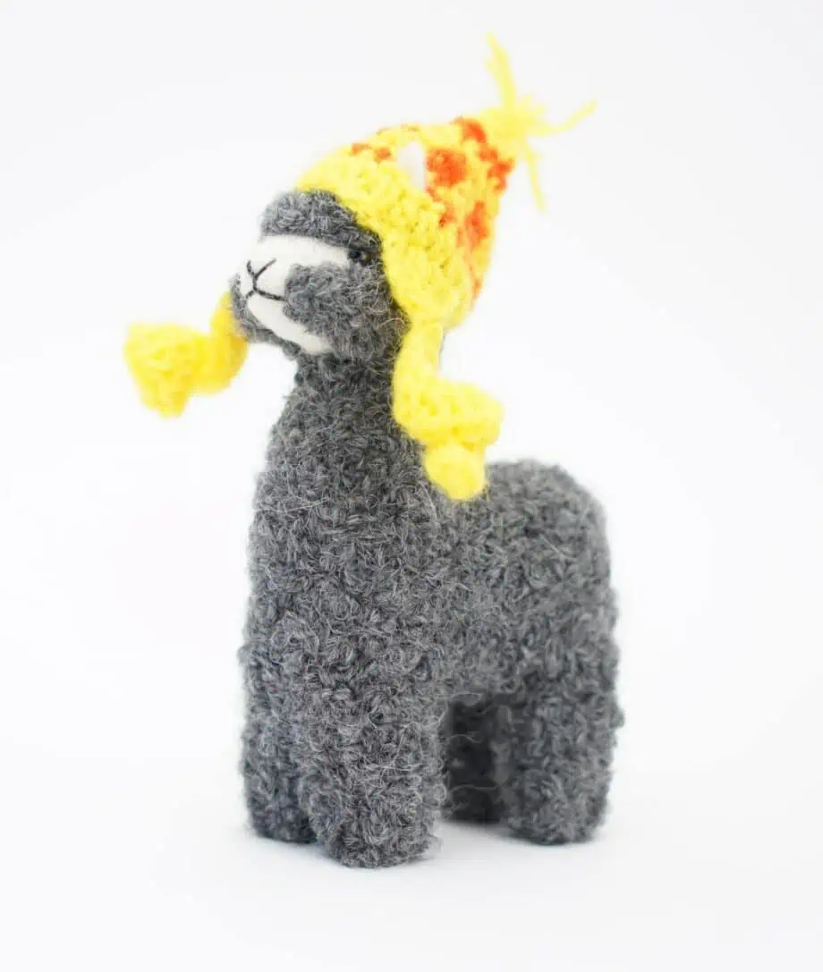 Cute grey baby alpaca with a yellow hat