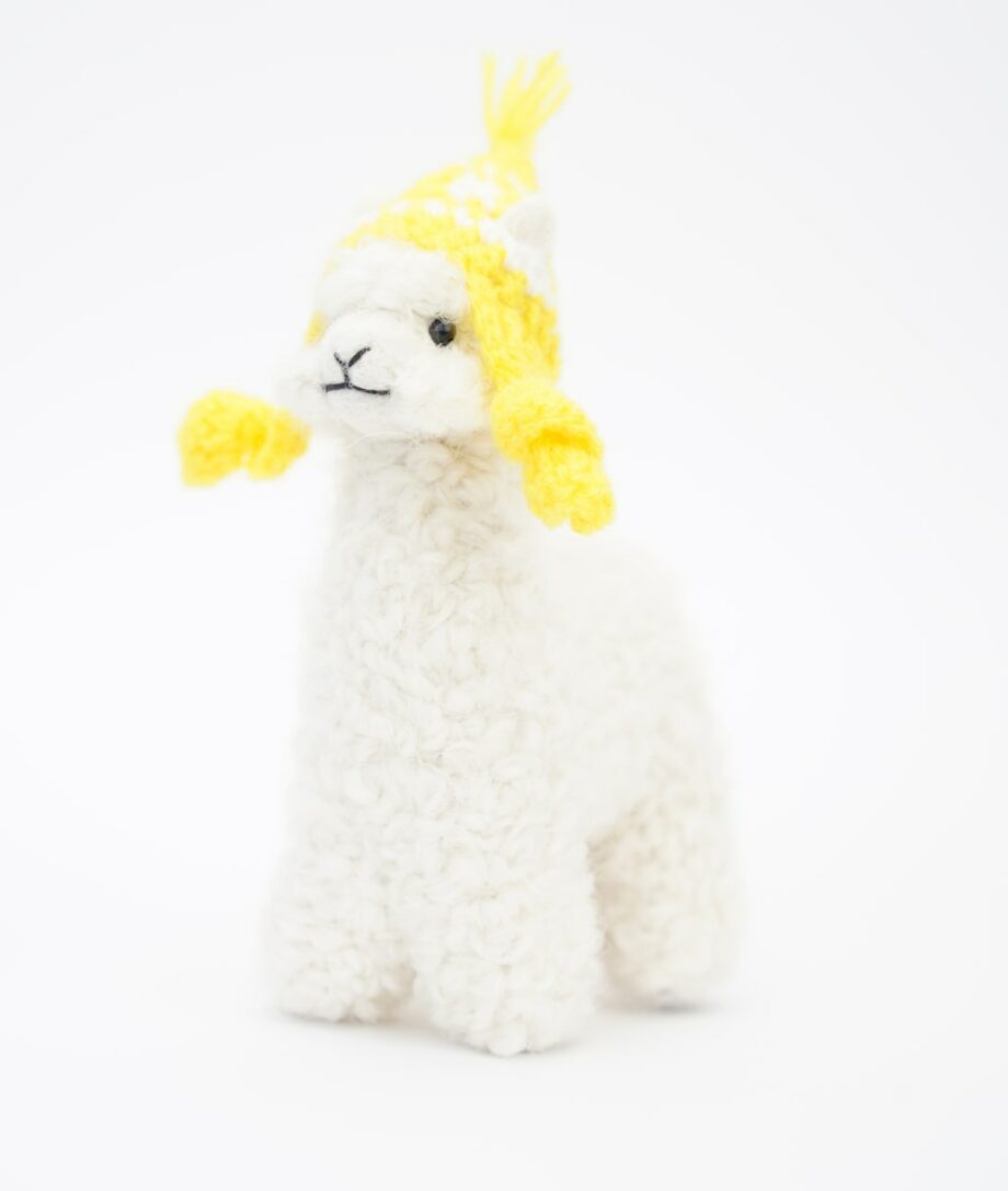cute white baby alpaca soft toy with a yellow hat