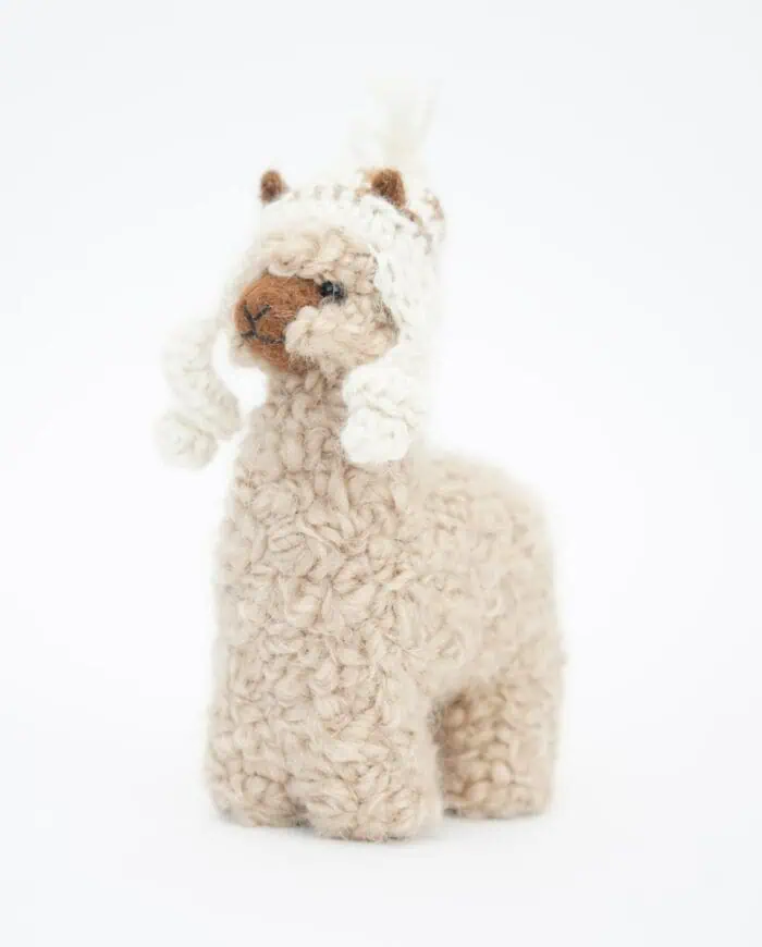 cuddly and cosy baby alpaca soft toy with a cream colour hat