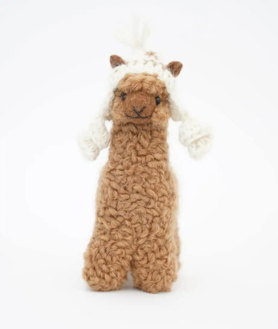 cute brown baby alpaca with a cream hat